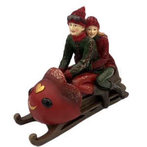 Para w czerwono zielonych ubraniach siedząca na saniach (poliresing) 22,5*11*18,5 cm